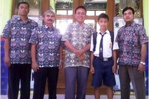 Akas Susanto berfoto bersama dengan kepala sekolah dan gurunya.